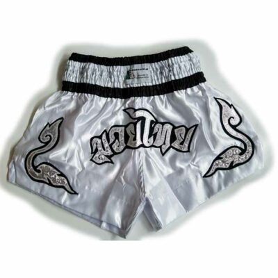 Weiße Muay Thai Shorts mit schwarzen und silbernen Stickereien und breitem Bund für perfekten Sitz.