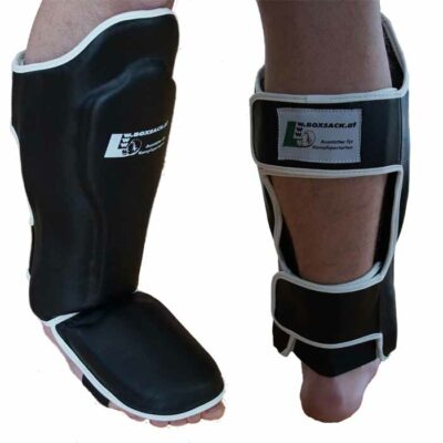 Schienbeinschoner aus Rindsleder mit integriertem Ristschutz in Schwarz für Muay Thai Training.