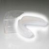 Einfacher Zahnschutz in transparenter Farbe, geliefert in einer hygienischen Aufbewahrungsdose.