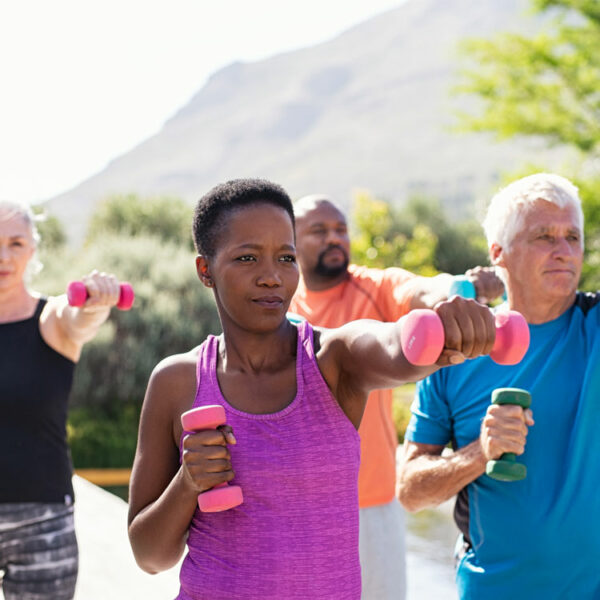 Outdoor-Workout-Gruppe mit Kurzhanteln in verschiedenen Farben.
