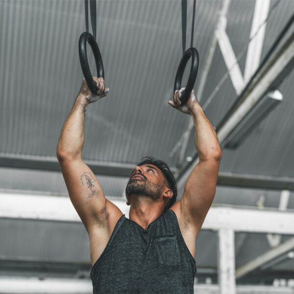 Sportler trainiert mit Gymnastikringen für Muskelaufbau und Körperstabilität.